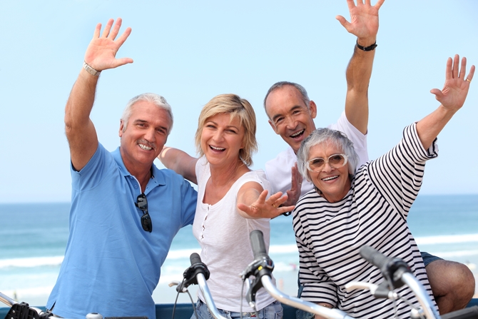 Retired couples on beach bike ride